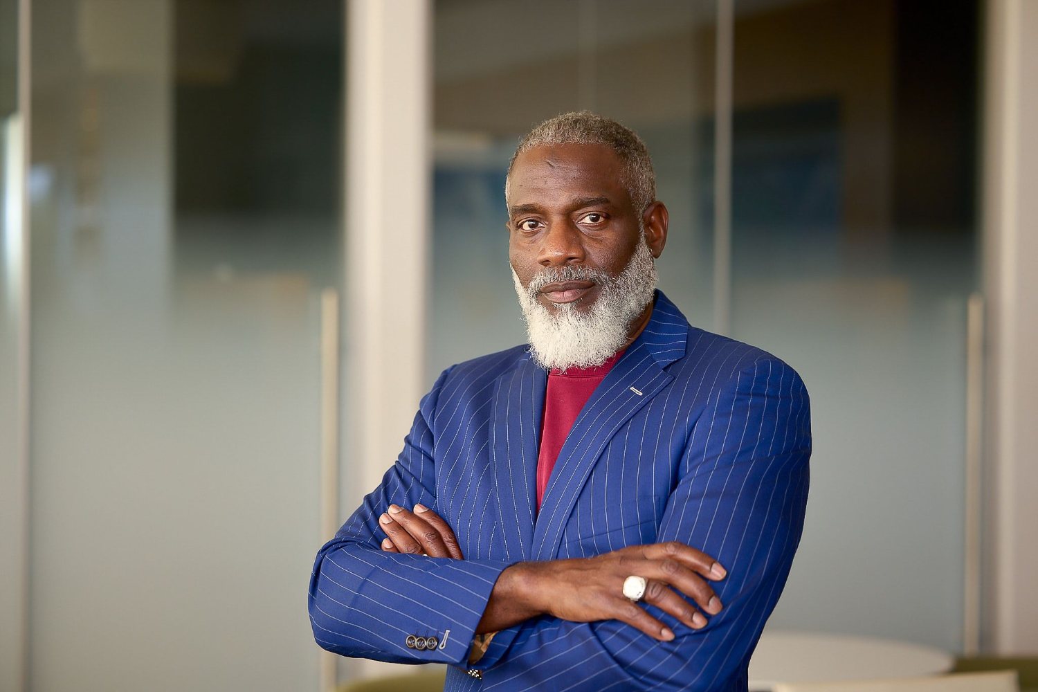 Myron Golden in a blue suit with arms crossed